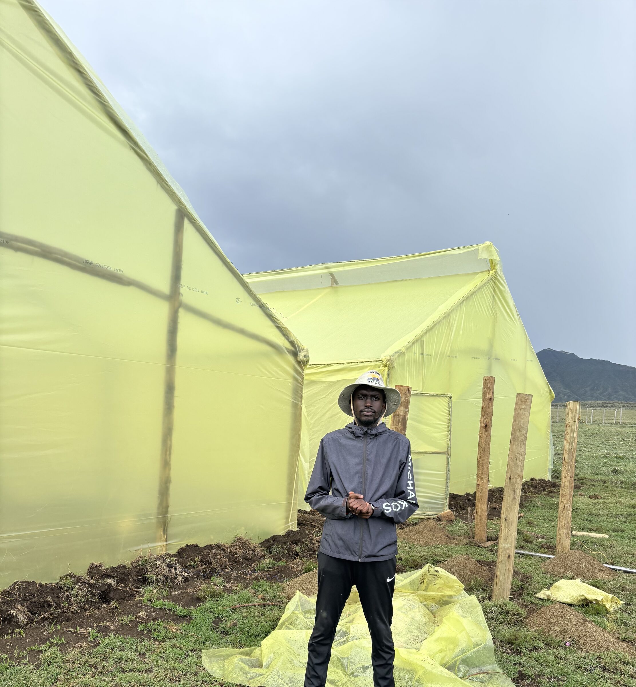 A member of the Chasing Sun farm team outside newly built greenhouse tunnels